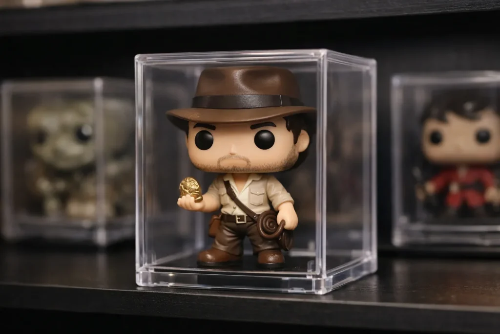Une figurine miniature dans un boîtier transparent, exposée parmi d’autres petits boîtiers de collection.