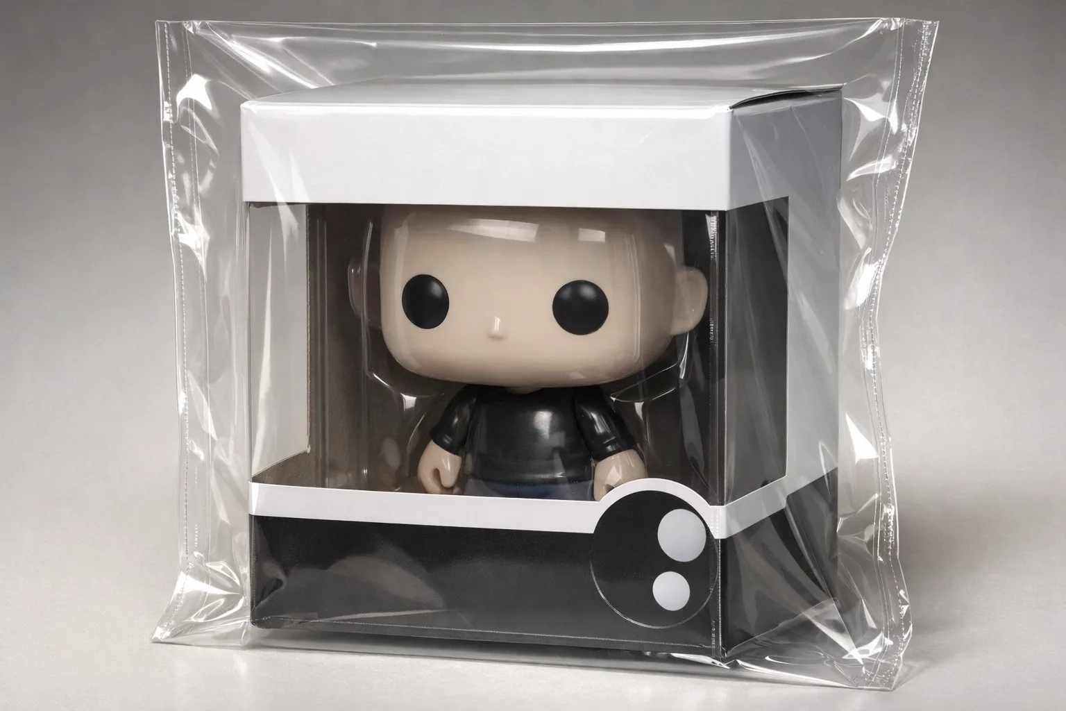 Une boîte de figurine de collection est enveloppée dans une pochette transparente souple.
